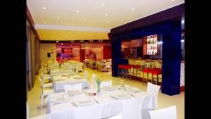 jadalnia z białymi stołami i białymi krzesłami w obiekcie Hotel Zodiaco w mieście Porto Cesareo