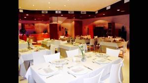 a dining room with white tables and white chairs at Hotel Zodiaco in Porto Cesareo