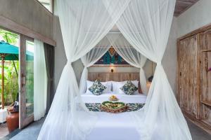 Postel nebo postele na pokoji v ubytování Uma Githa Ubud by Pramana Villas