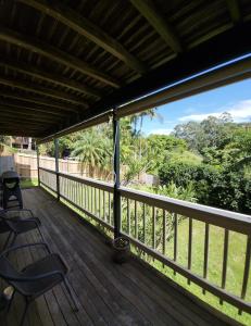a porch with two chairs and a view of the ocean at Bushland View Retreat in Ocean Shores