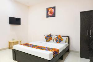 a bedroom with a bed with a tv on the wall at FabHotel Rachana Residency - Nr Shivaji Nagar Metro Station in Pune +28 photos