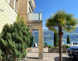 palma di fronte a un edificio con balcone di Hotel Fähri Gersau a Gersau