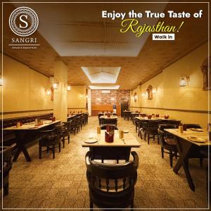 a restaurant with tables and chairs in a room at Kiaan Inn in Kolkata