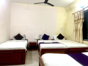 a room with four beds in it with a ceiling at Hotel Blue lake in Pokhara