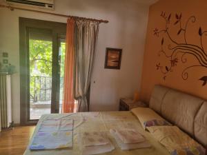 a bedroom with a bed and a couch and a window at Poly's House in Kavála
