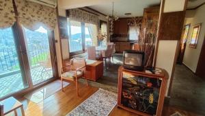 a living room with a television and a dining room at Poly's House in Kavála