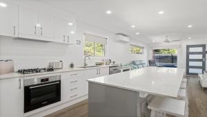 a kitchen with white cabinets and a white counter top at 52a Chalmers Street Flynns Beach in Port Macquarie