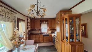 a kitchen with wooden cabinets and a chandelier at Poly's House in Kavála