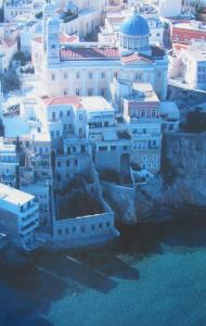 un grupo de edificios en una ciudad junto al agua en Apollonos Seafront Apartment, en Ermoupoli