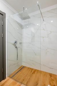 a bathroom with a shower with white marble walls at Q Villa in Săcele +14 photos
