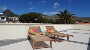 two chairs sitting on a balcony with mountains in the background at Sotavento Guest House in Porto Santo