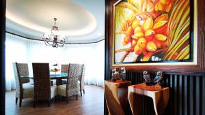 Un comedor con una mesa y un cuadro en la pared. en Tiara Golf Villa With Pool, en Melaka