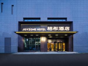 a building with a sign that reads yoyono hotel at 桔作酒店 新乡东站市政府店 in Xinxiang