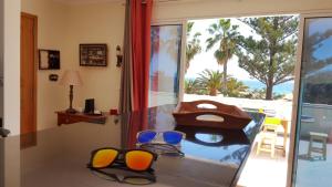 a room with a glass table with chairs and a window at Sotavento Guest House in Porto Santo