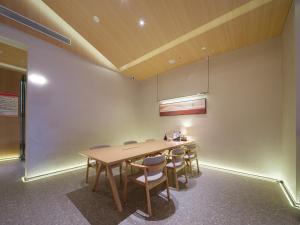 a dining room with a wooden table and chairs at 桔作酒店 新乡东站市政府店 in Xinxiang