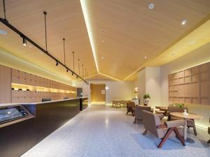 an office lobby with tables and chairs and a cafeteria at 桔作酒店 新乡东站市政府店 in Xinxiang