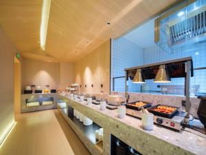 a restaurant with a buffet line with food at 桔作酒店 新乡东站市政府店 in Xinxiang