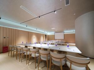 a large conference room with a long table and chairs at 桔作酒店 新乡东站市政府店 in Xinxiang