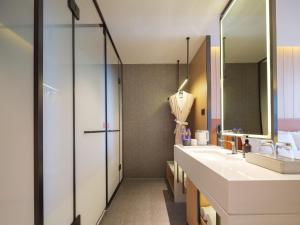 a bathroom with two sinks and a shower at 桔作酒店 新乡东站市政府店 in Xinxiang
