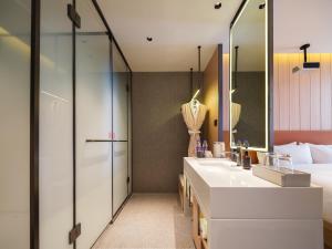 a bathroom with two sinks and a shower at 桔作酒店 新乡东站市政府店 in Xinxiang