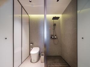 a bathroom with a toilet and a shower at 桔作酒店 新乡东站市政府店 in Xinxiang