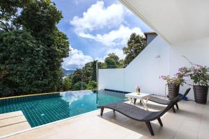 a swimming pool with two chairs and a table on a patio at Private 3-Storey Pool Villa Atika 10, for 7, views of Patong Bay in Patong Beach