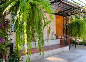 a patio with a bench and plants in a building at บ้านพักบุหงา199 อ สรรพยา in Sanphaya