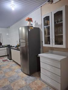 a kitchen with a stainless steel refrigerator and cabinets at Casa albatroz Imbé in Imbé
