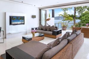 a living room with a couch and a table at Private 3-Storey Pool Villa Atika 10, for 7, views of Patong Bay in Patong Beach