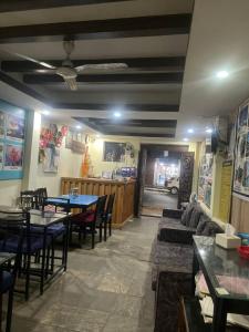 a restaurant with a couch and tables and chairs at Hotel Blue lake in Pokhara