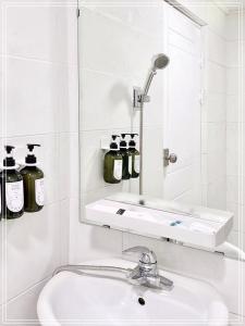 Un baño blanco con lavabo y espejo. en Goyo inn Sillim, en Seúl