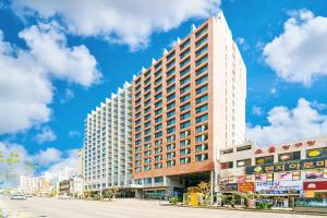 a tall white building on a city street at Hotel Air City Jeju in Jeju