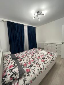a bedroom with a bed with a floral comforter at Ioanic Modern Apartment with Parking in Ploieşti