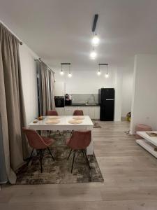 a white table and chairs in a room with a kitchen at Ioanic Modern Apartment with Parking in Ploieşti