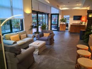 a living room with couches and chairs and a table at Hotel La Capannina in Genova
