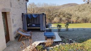 a bed in a shed with a table and a bench at L'ecrin de lacoste in Chasteaux