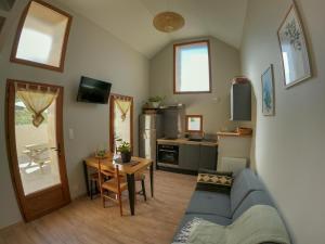 a living room with a blue couch and a kitchen at L'ecrin de lacoste in Chasteaux