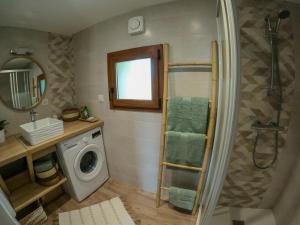 a bathroom with a shower and a washing machine at L'ecrin de lacoste in Chasteaux
