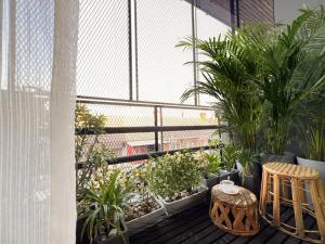 a balcony with plants and a table and chairs at Enjoyo Getaway in Bangkok