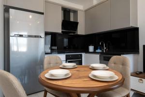 a kitchen with a wooden table with chairs around it at Seda Holiday in Alanya +32 photos