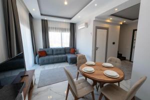 a living room with a table and chairs and a couch at Seda Holiday in Alanya