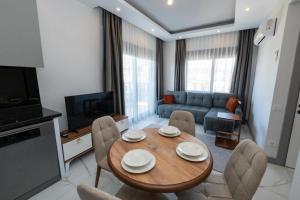 a living room with a wooden table and chairs at Seda Holiday in Alanya