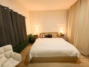 a bedroom with a white bed and a chair at Enjoyo Getaway in Bangkok
