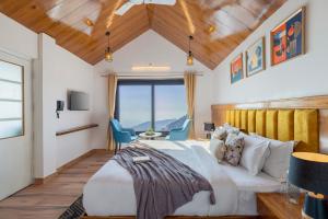 ein Schlafzimmer mit einem großen Bett mit einem großen Fenster in der Unterkunft Alaya Stays Evara Serene 4 BHK Hill Retreat with Balcony, Fireplace & Scenic Views in Masuri