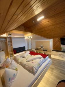 メッケンベウーレンにあるLandhaus Monikaのベッドが2つあり、天井が木製の寝室