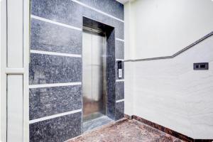 a walk in shower with a black and white wall at Hotel Elite Inn in Dehradun +1 photo