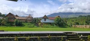a group of houses with mountains in the background at Bale Gantar in Sembalun Lawang