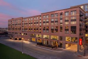 苏福尔斯Canopy By Hilton Sioux Falls Downtown的一座大型砖砌建筑,上面有公司标志