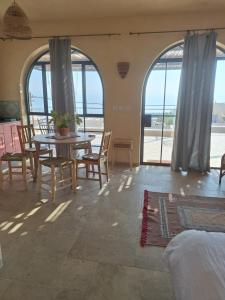 a room with a table and chairs and a view of the ocean at ים ומדבר in Ovnat