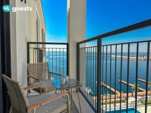 a balcony with a table and chairs and a view of the ocean at HiGuest - Stylish 1BR Apartment in La Mer in Dubai